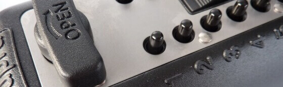 Nahaufnahme eines Bedienfelds mit Schaltern und einem Hebel mit Aufschrift 'OPEN' Detailansicht einer Steuerungseinheit mit mehreren Kippschaltern und einem Hebel, auf dem 'OPEN' steht